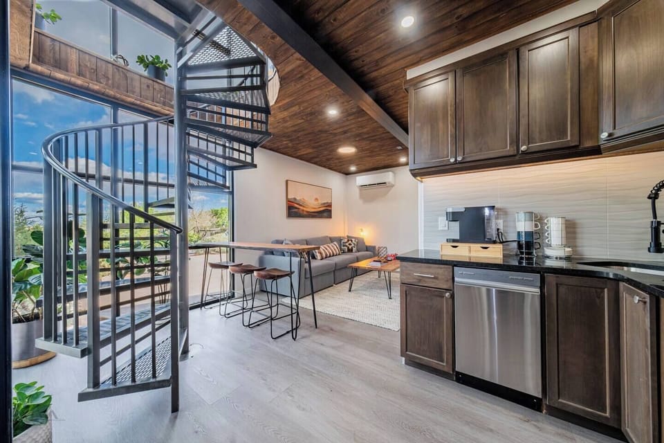 Kitchen area with modern appliances and spiral staircase.