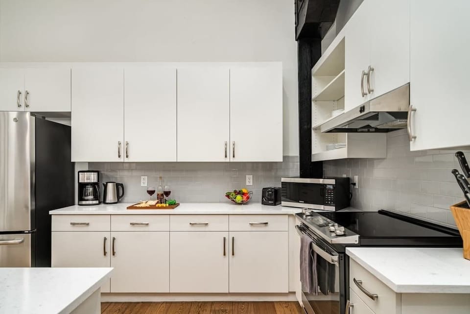 Fully equipped kitchen featuring stainless steel appliances, open counter space, and bar seating for 5 guests.
