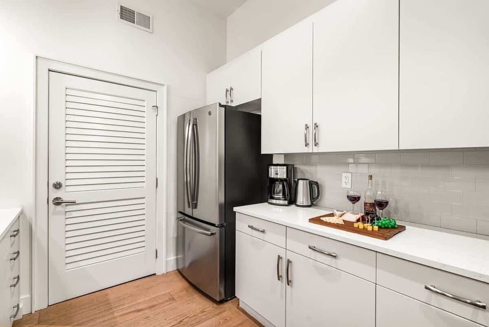 Fully equipped kitchen featuring stainless steel appliances, open counter space, and bar seating for 5 guests.