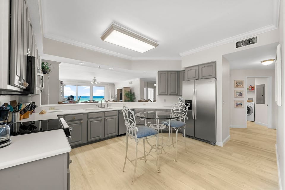 Modern kitchen with gray cabinetry and ocean views in the background