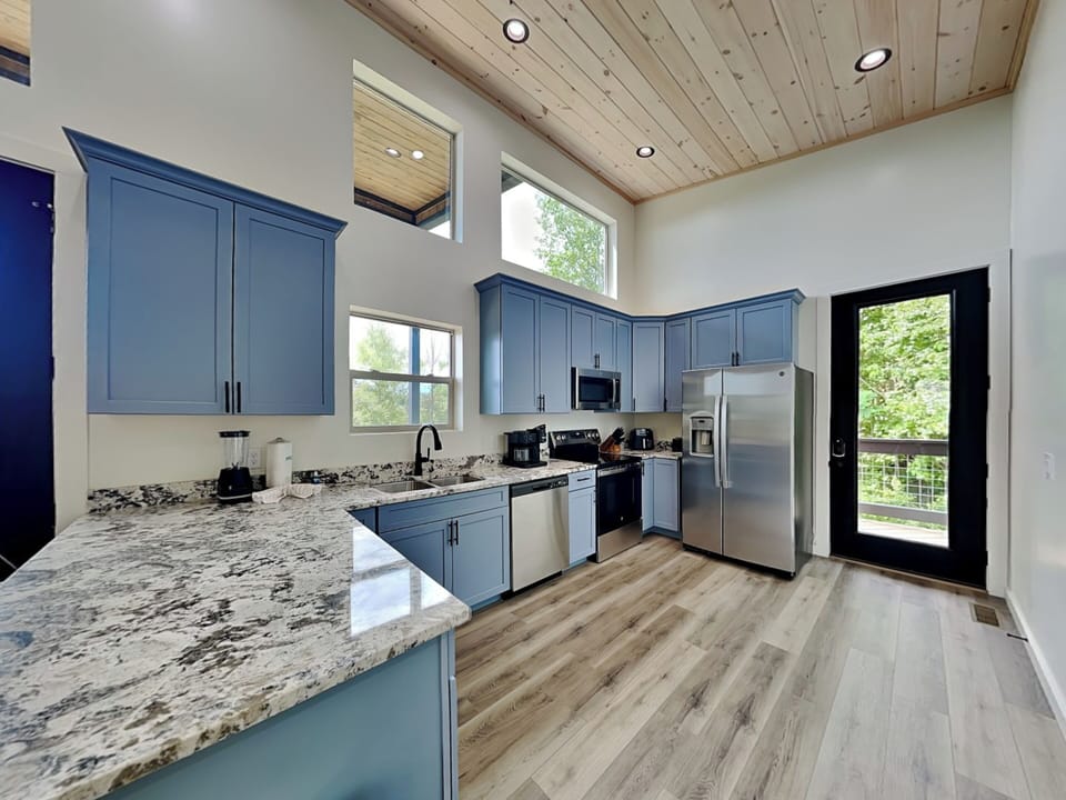 Fully Equipped Kitchen with Stainless Steel Appliances and Breakfast Bar Seating for Two