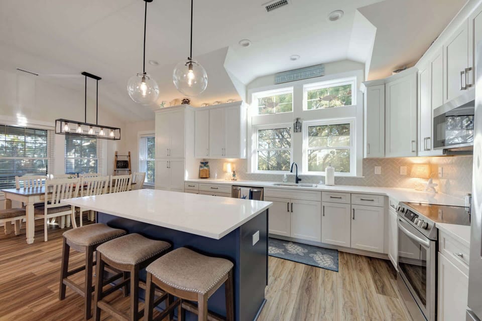 Updated kitchen with quartz countertops, stainless steel appliances, and expansive island with bar seating for 3