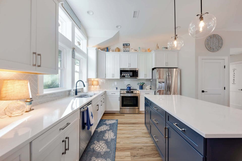 Updated kitchen with quartz countertops, stainless steel appliances, and expansive island with bar seating for 3