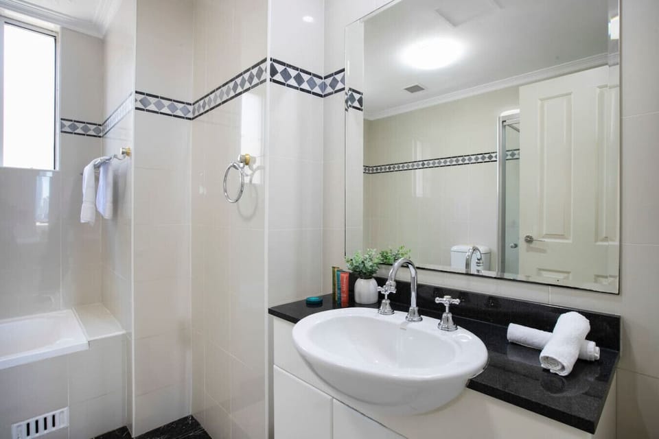 Refresh in the bright bathroom, complete with a generous vanity, bathtub and glass shower screen.