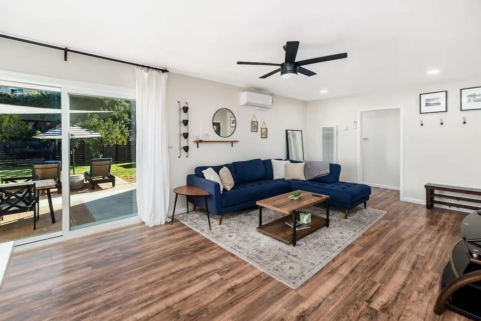 Inviting living room with stylish navy sofa, wood floors, and patio access