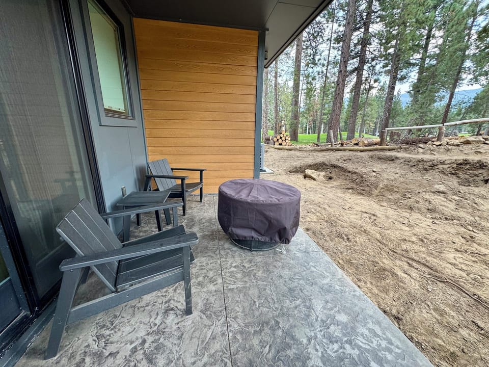 Patio off of downstairs bedroom with seating area and firepit.