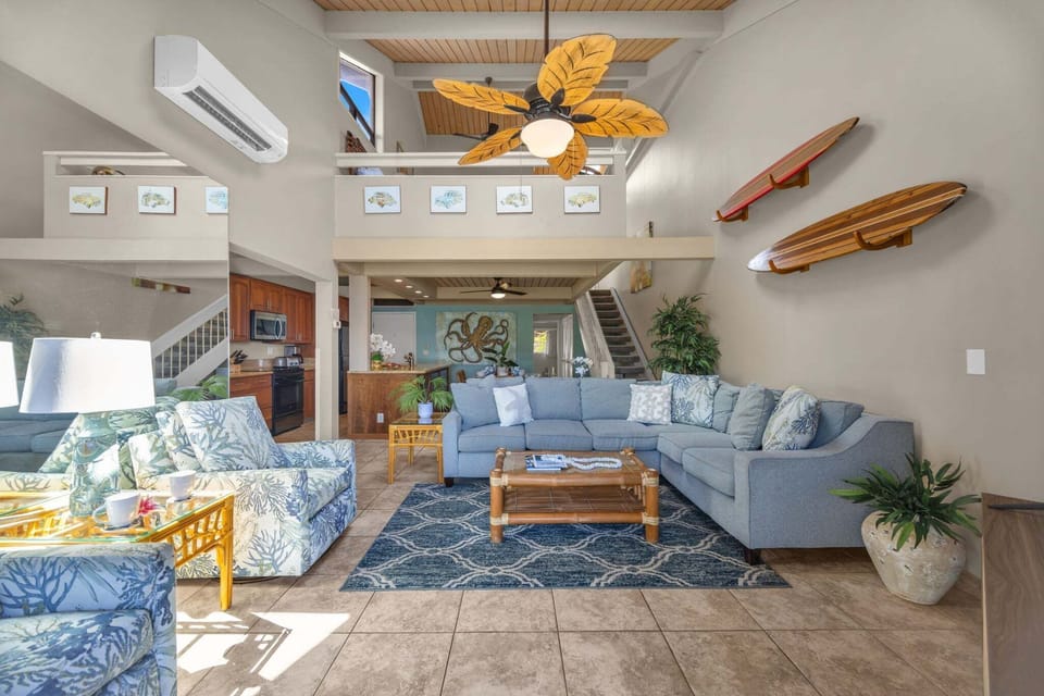Surfboards on the wall echo the theme, tropical light spilling across the patterned rug.