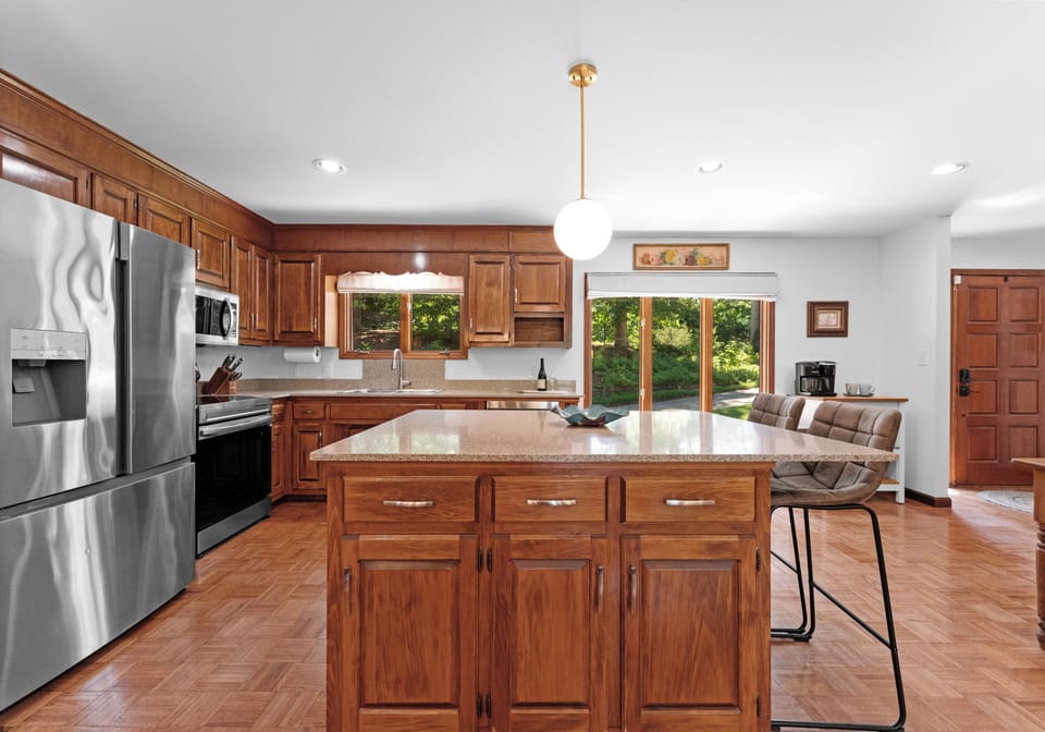 Fully equipped kitchen with wood cabinetry and stainless steel appliances.