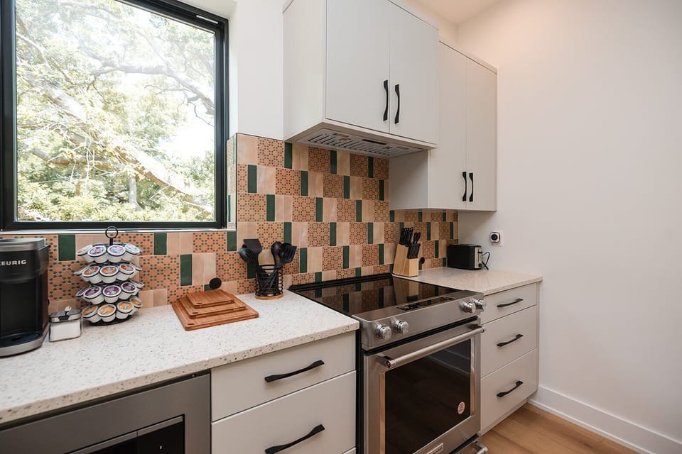 The gourmet kitchen is fully equipped with high-end KitchenAid appliances, quartz countertops, cookware, spices, and everything needed for hosting.