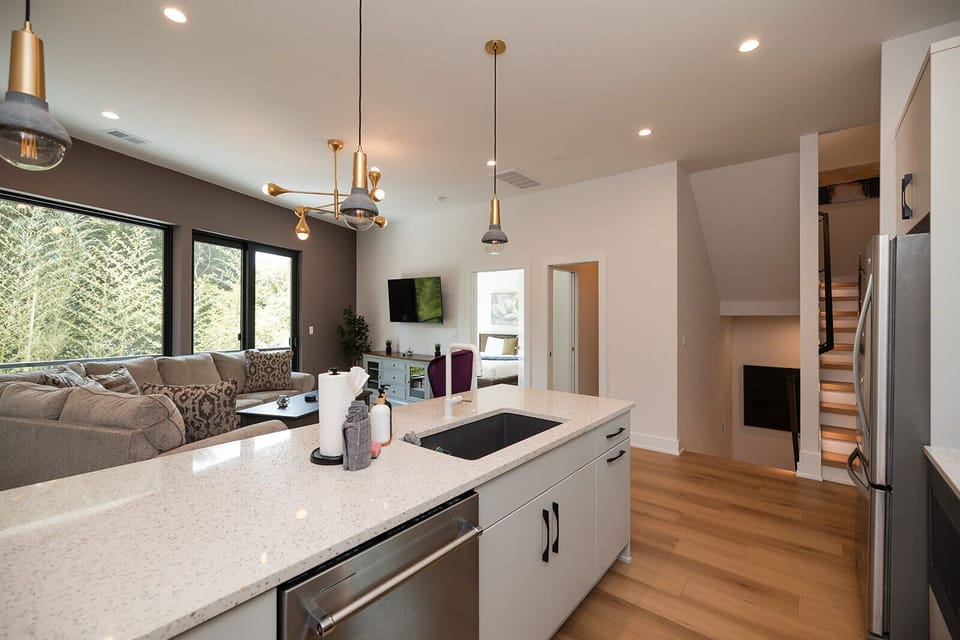 The gourmet kitchen is fully equipped with high-end KitchenAid appliances, quartz countertops, cookware, spices, and everything needed for hosting.