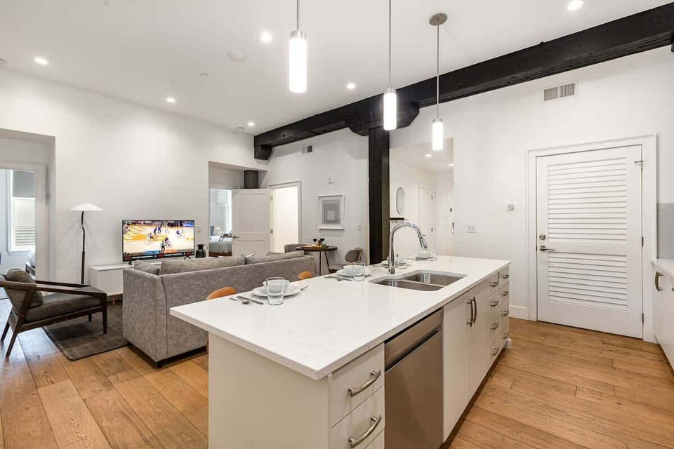 Fully equipped kitchen featuring stainless steel appliances, open counter space, and bar seating for 4 guests.