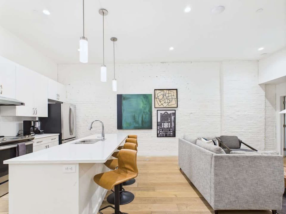 Open-concept living area featuring cozy furnishings, smart TV, small dining area with seating to 2 guests and a sleeper sofa.