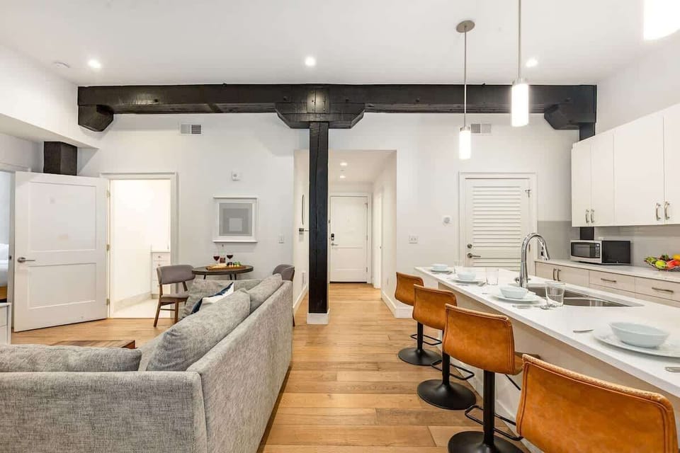 Open-concept living area featuring cozy furnishings, smart TV, small dining area with seating to 2 guests and a sleeper sofa.