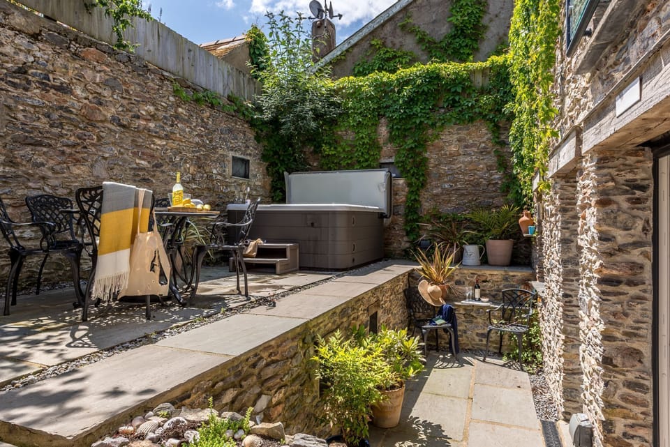 Garden patio with seating, hot tub, bistro table and chairs- The Old Chapel