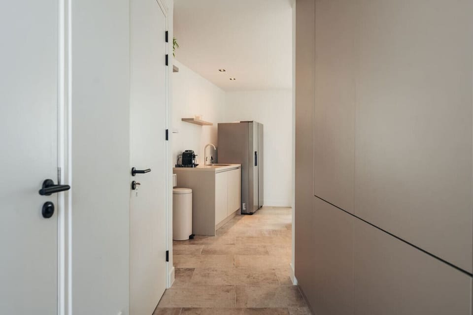 Clean, modern, and fully equipped—this hallway leads you straight to your homey kitchen setup, ready for whatever your day brings.