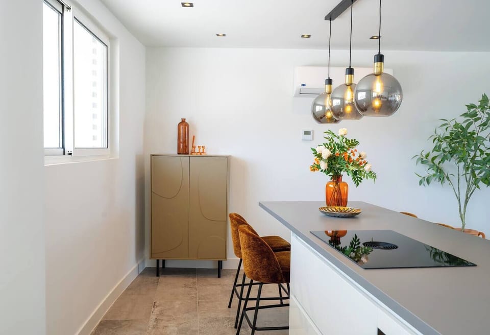 Clean kitchen with island seating—perfect for quick meals, coffee, or catching up while you cook.