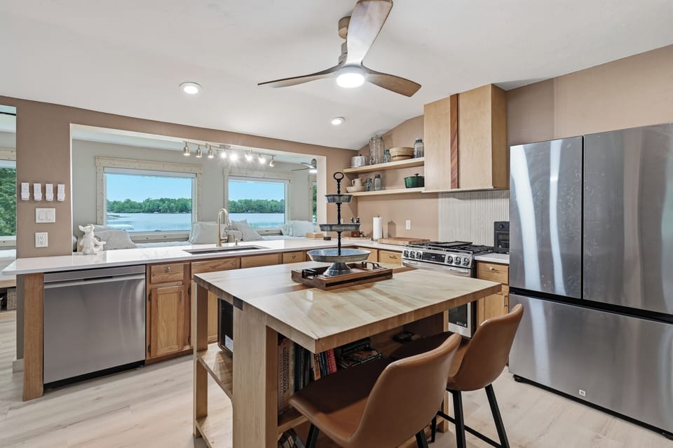 The kitchen is perfectly situated in the center of the upper level, allowing you to prepare meals while still spending time with family and friends in the dining room or on the daybeds. Bonus: It also features panoramic lake views!