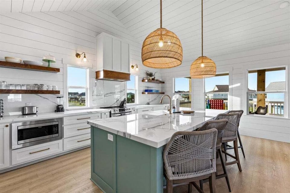 Open kitchen with stainless steel appliances and spacious dining area