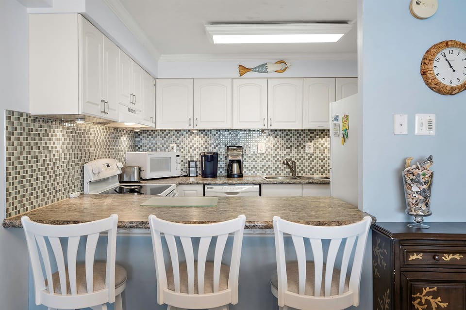 Fully stocked kitchen with breakfast bar seating for three
