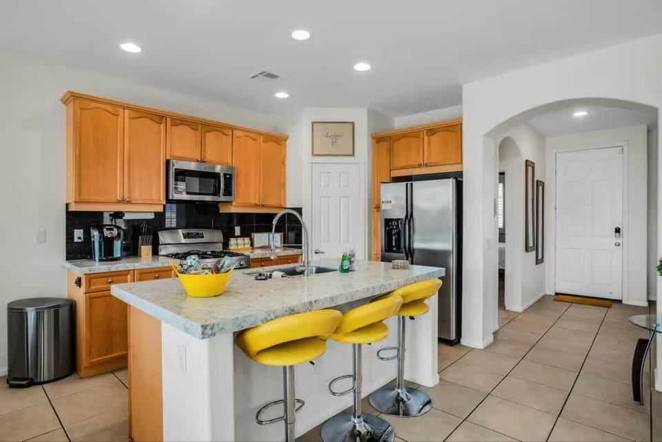Bright, fully stocked kitchen with island seating and modern appliances.