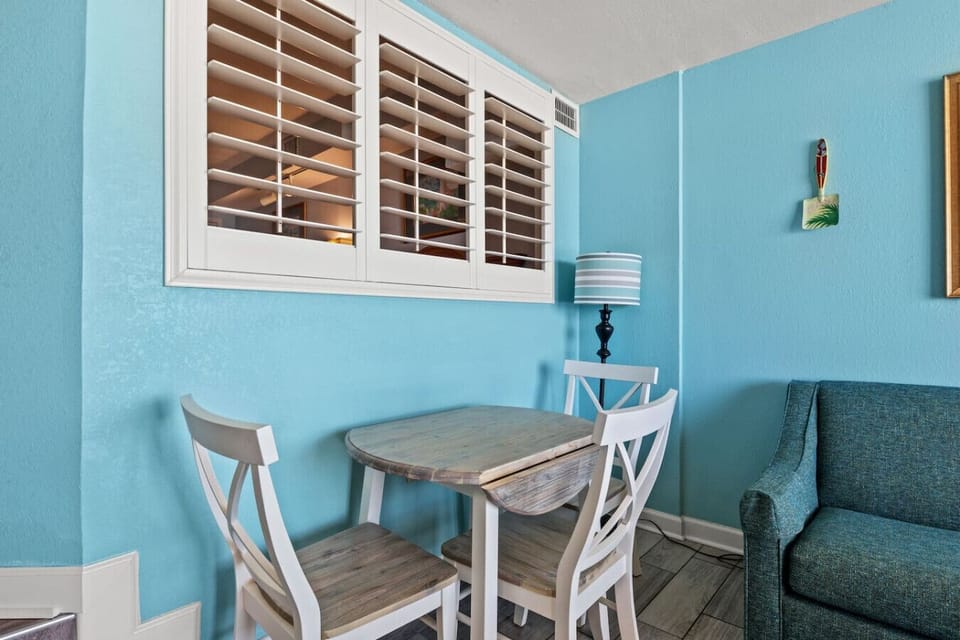Modern beach-style living room with seating for four—great for family meals, game nights, or relaxing after a day in the sun. Coastal decor and a cozy setup create the perfect spot for making unforgettable vacation memories.