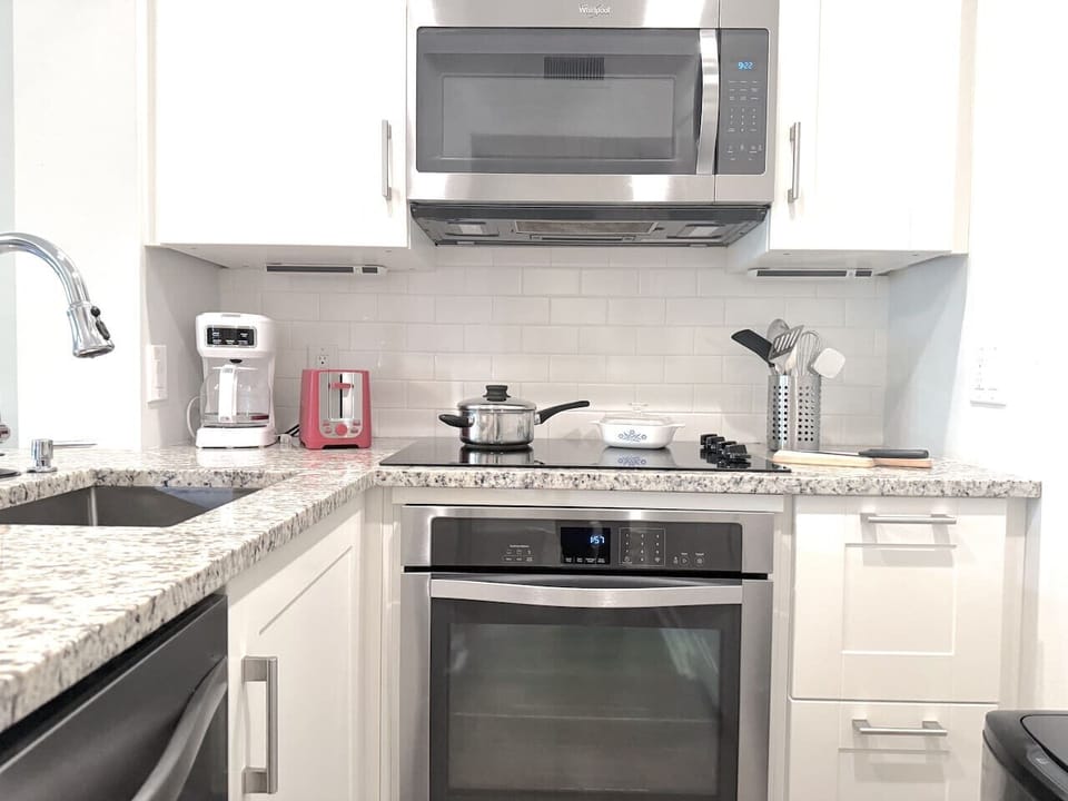This full kitchen is stocked with modern appliances including Oven with countertop stove, dishwasher, microwave, refrigerator / freezer, sink, toaster, drip & k-pod Keurig coffee makers, cookware, dinnerware, silverware, and blender.