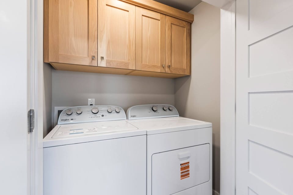 Your laundry stays simple and convenient with an in-unit washer and dryer tucked neatly beneath stylish oak cabinetry, so you can pack light and enjoy your getaway.