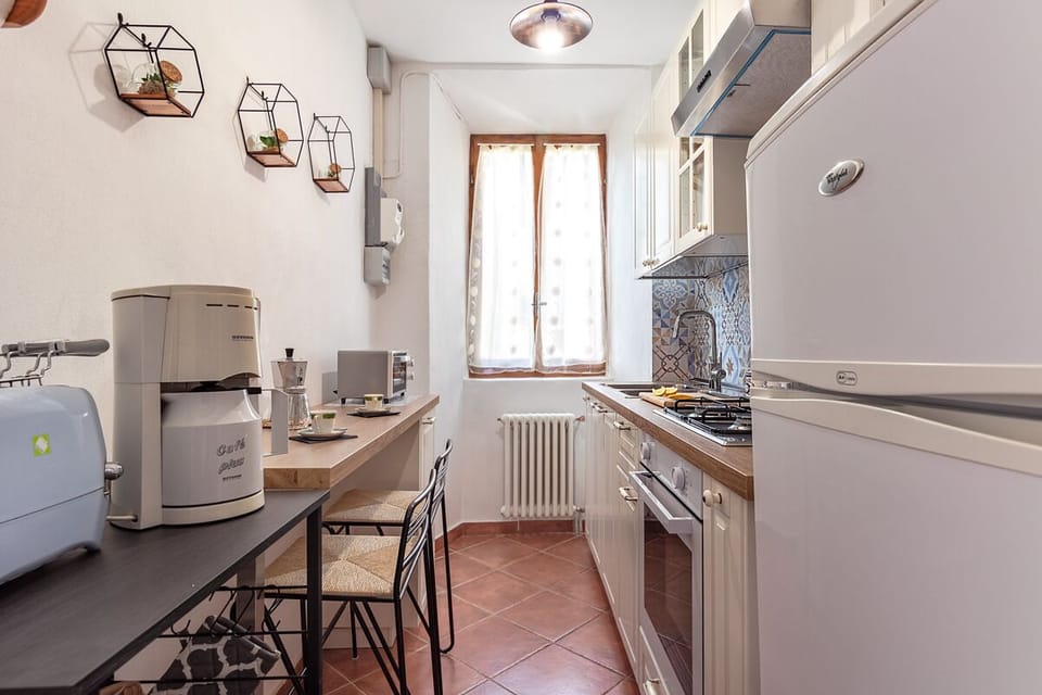 Kitchen: oven, refrigerator, kettle, toaster, moka pot, microwave, dishes.