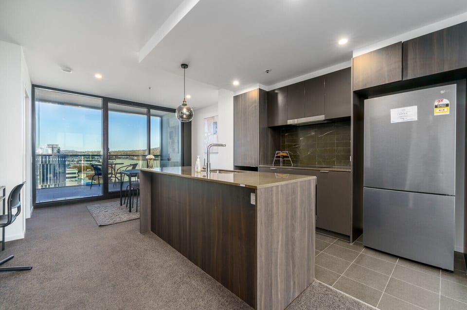 Functional and inviting kitchen featuring a full-size fridge, oven, microwave, and all your cooking essentials.