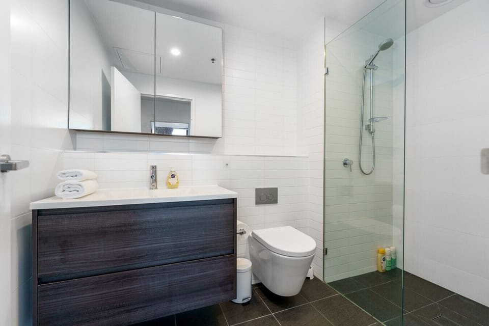 Modern bathroom with a clean shower and toilet, designed for convenience and comfort.