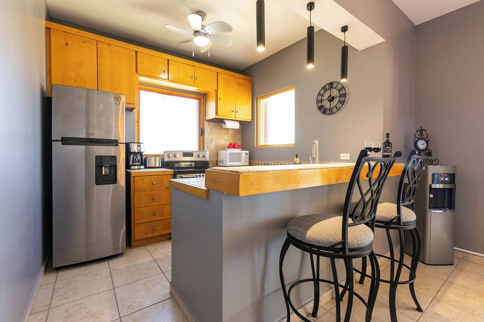 Fully equipped kitchen with bar-top seating, fridge, stove, and dishwasher for a convenient cooking experience