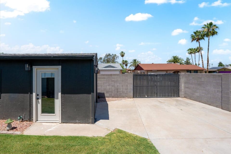 Private suite with a sleek black exterior and gated driveway access.