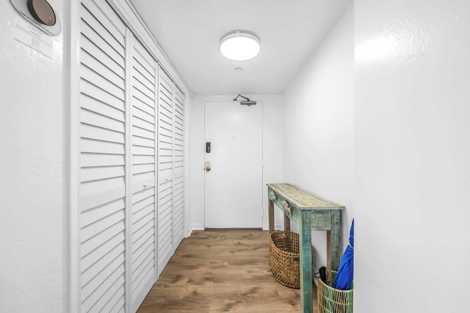 Entryway with white louvered closet doors and rustic wooden console table