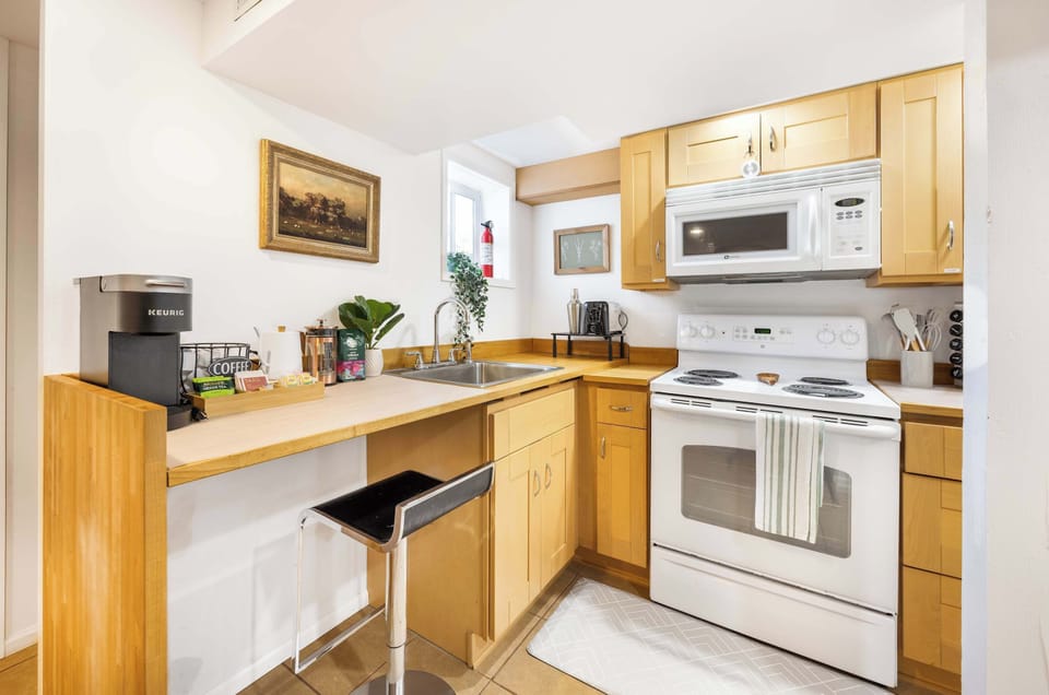 Compact wooden textured Kitchen besides a full equiped coffee station, small but have all the appliance and cook needs!