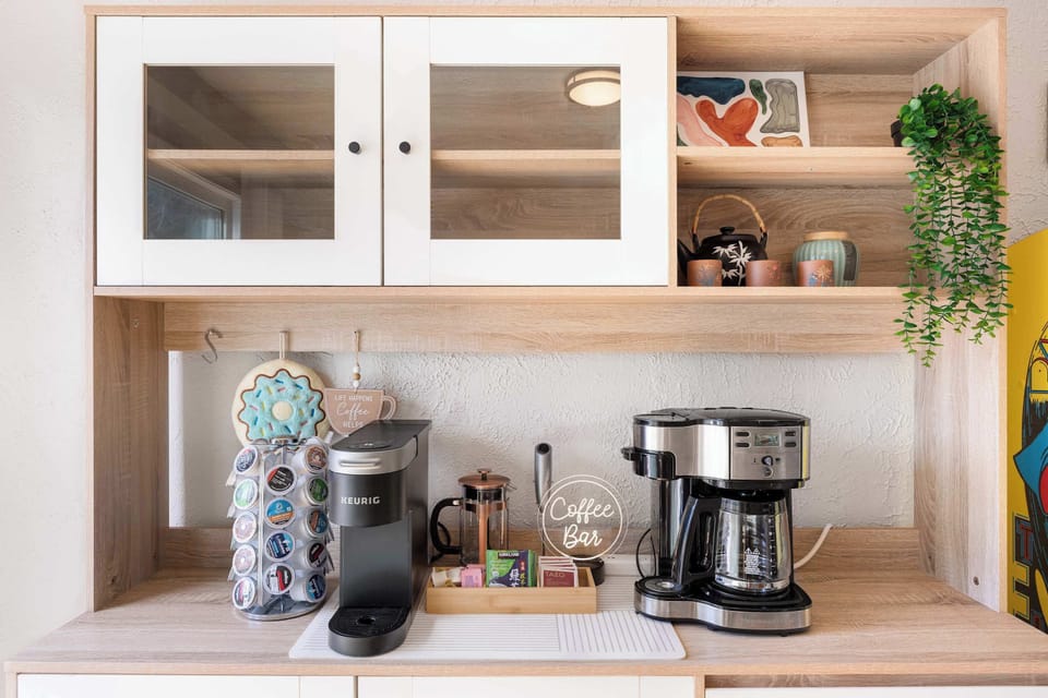 Morning rituals get a stylish upgrade with this dedicated coffee nook, where the Keurig machine, French press, and hanging plants transform caffeine fixes into a sensory experience.