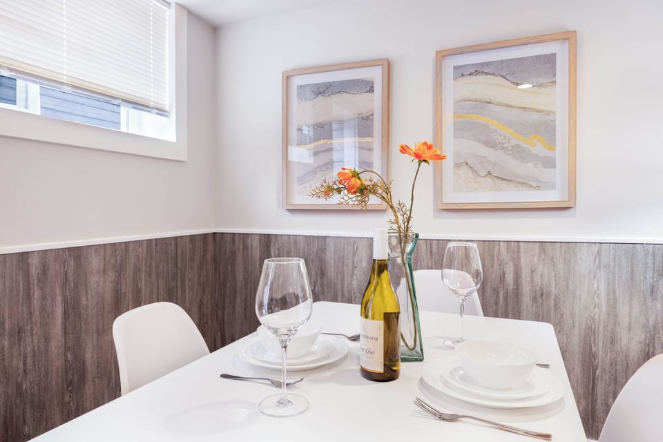 Gather around a minimalist wooden table, perfect for cozy dinners or casual chats with friends.