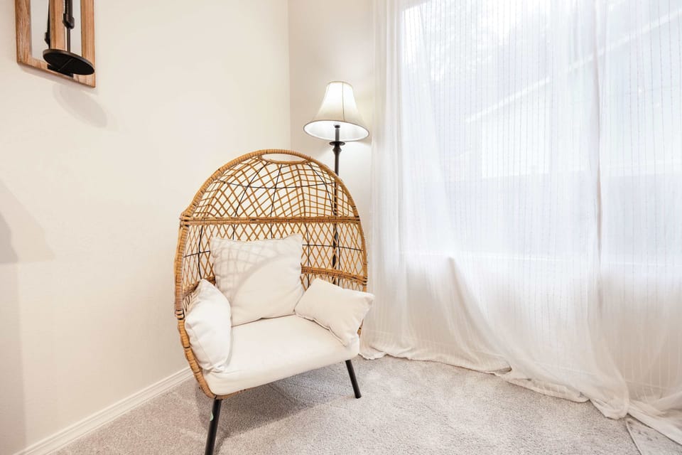 Another egg  chair next to the window, enjoying the natural light while reading a book.