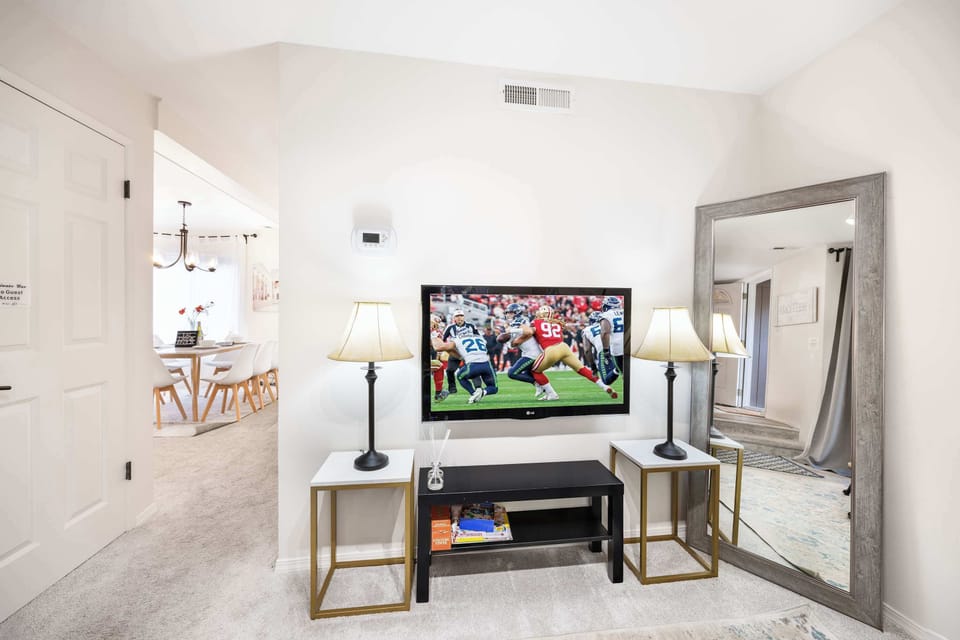 Modern living room with a sleek mirror and entertainment setup,perfect for hosting a movie night or game night here.