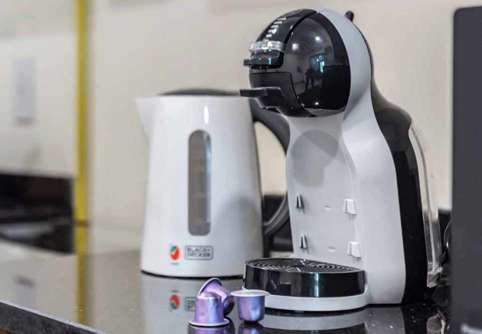 Start your day with ease, sleek coffee machine, electric kettle, and cozy vibes. A modern kitchen corner made for comfort and caffeine lovers.