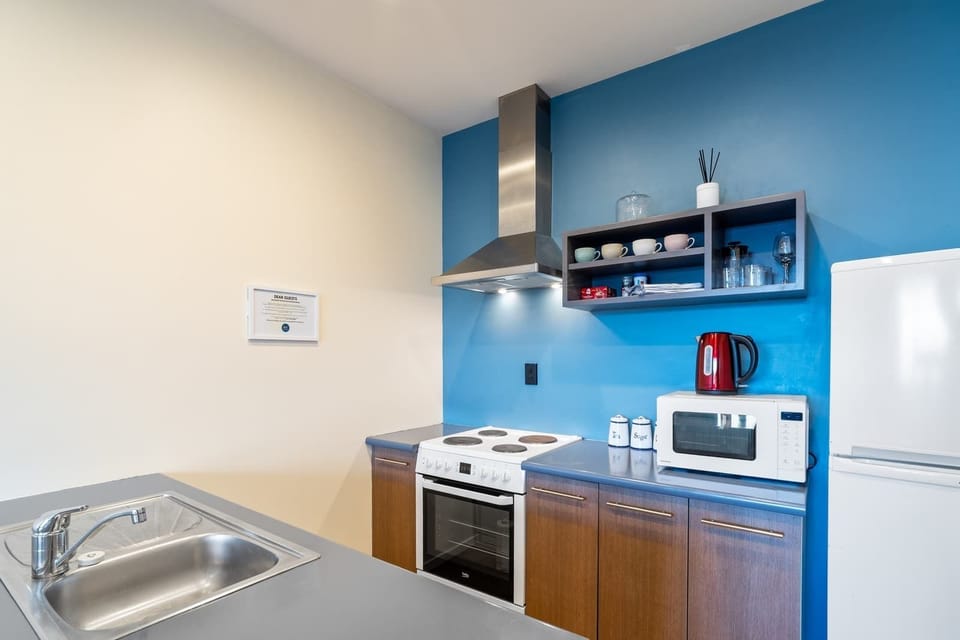 Fully equipped kitchenette with stove, microwave, and essentials—perfect for cooking simple meals at home.