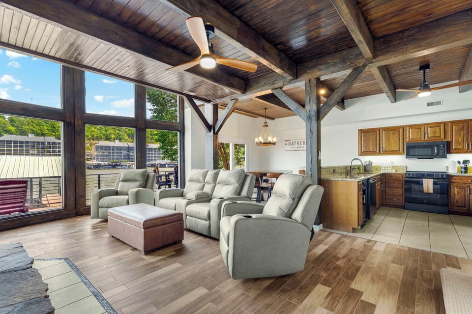 Spacious lower-level living room with big lakeview windows, seamlessly open to the kitchen and dining area—perfect for gathering, relaxing, and soaking in the view.