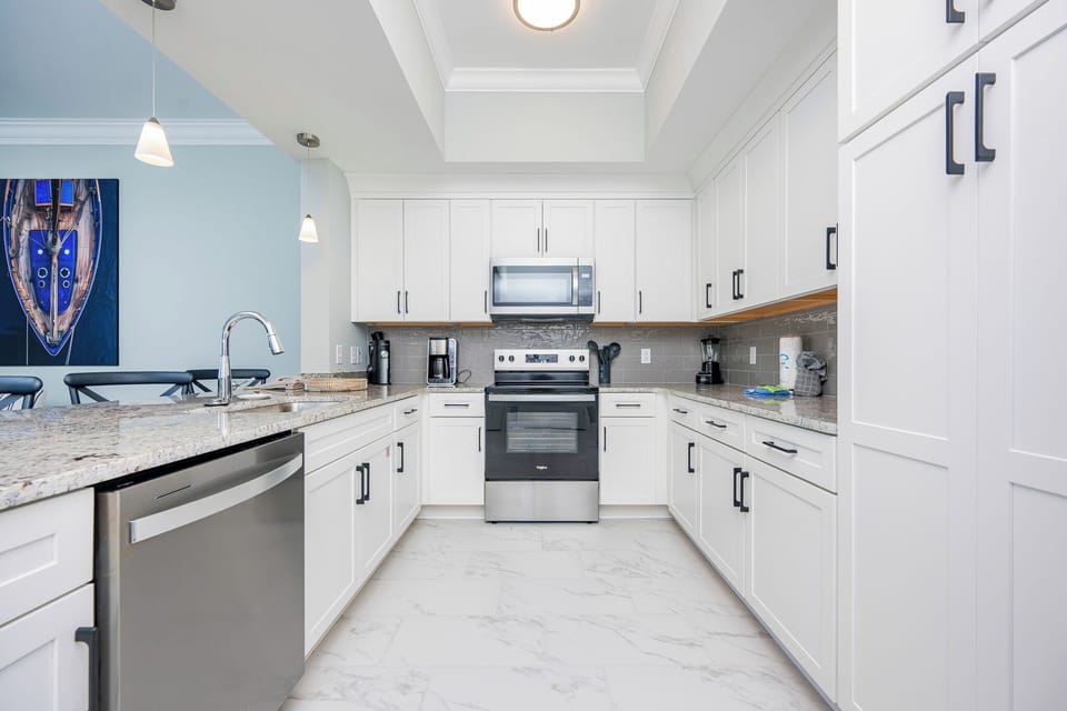 Prepare meals in this stylish kitchen with granite countertops, stainless appliances, and nautical artwork