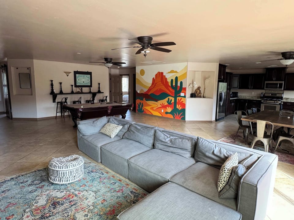 Open-concept living with comfortable seating and a vibrant desert mural.