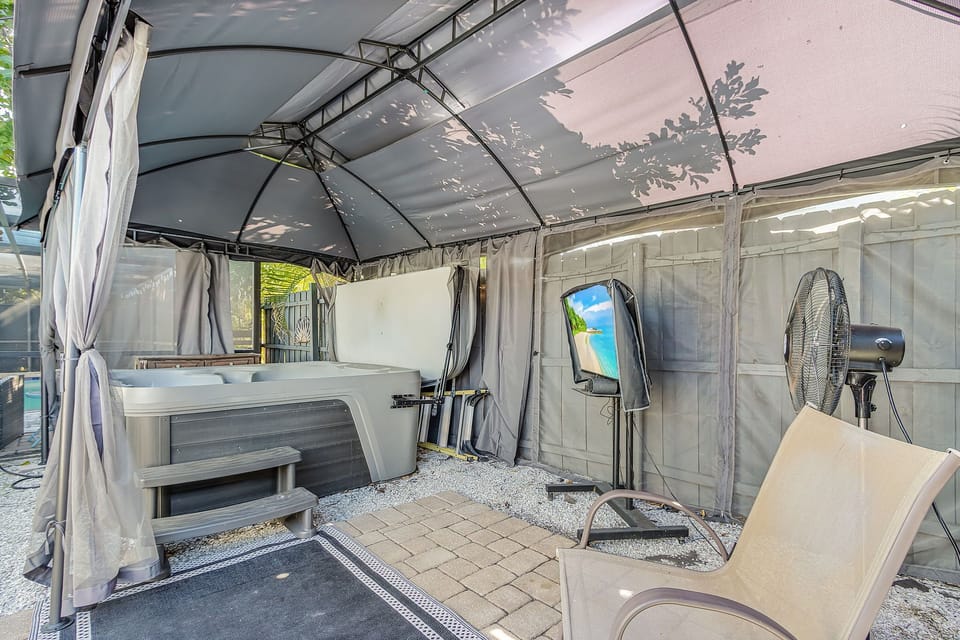 Covered hot tub and lounge area with TV