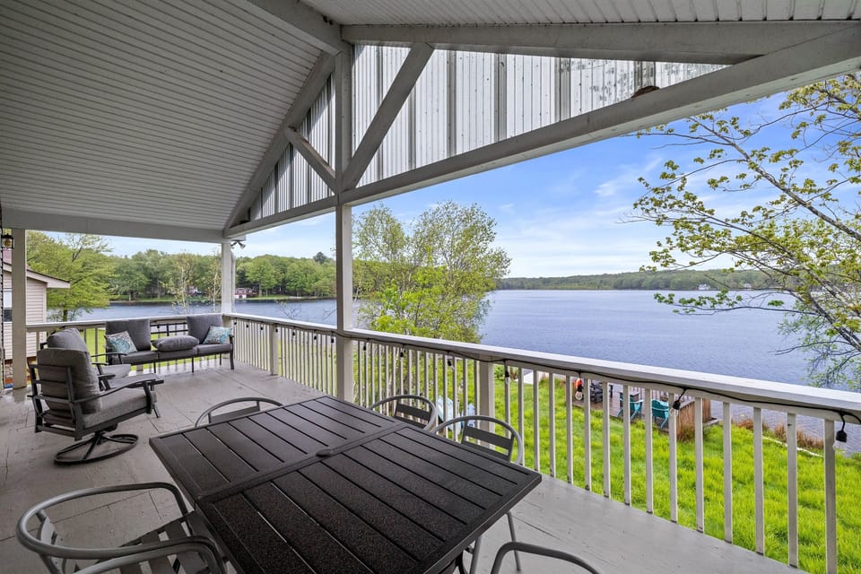 Covered upper-level deck with a seating area and outdoor dining table—ideal for meals with a view.