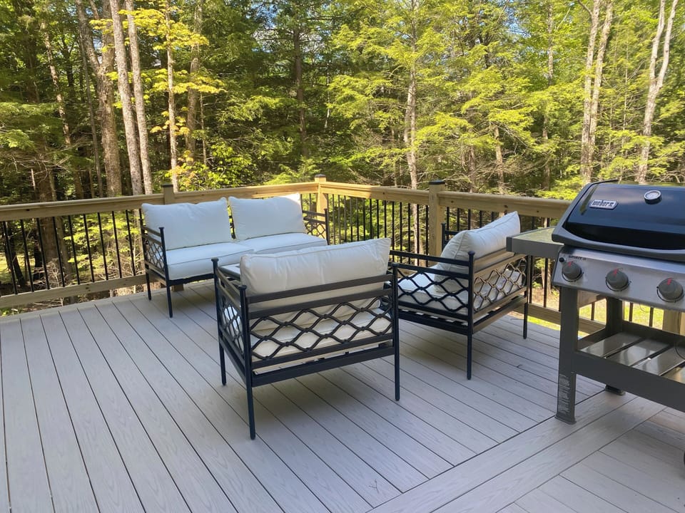 Large deck with seating and a gas grill.