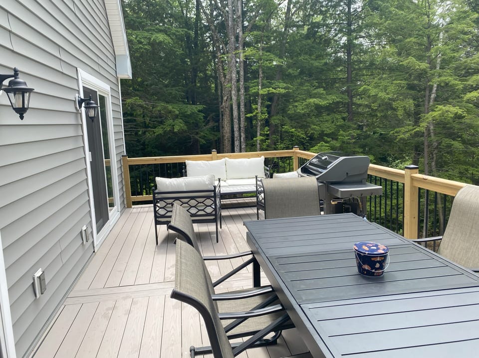 Large deck with seating and a gas grill.
