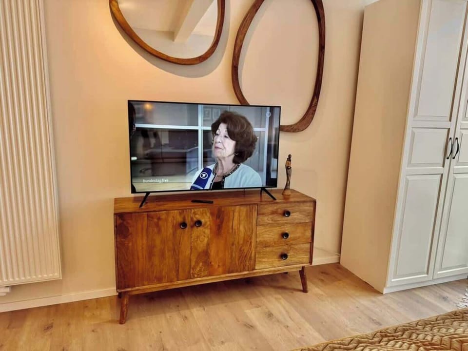 Entspanne auf dem gemütlichen Sofa mit Blick auf den Smart-TV – stilvoll eingerichtetes Wohnzimmer im Herzen von Celle.