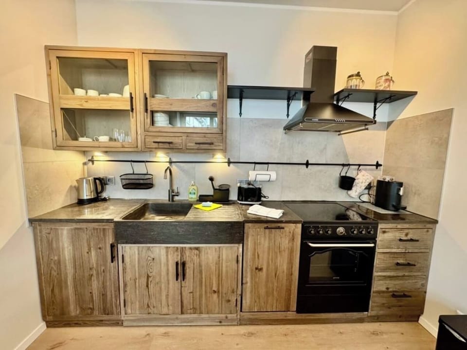Landhausküche mit Herd, Backofen & Kaffeemaschine – ideal für stilvolles Kochen wie zuhause.