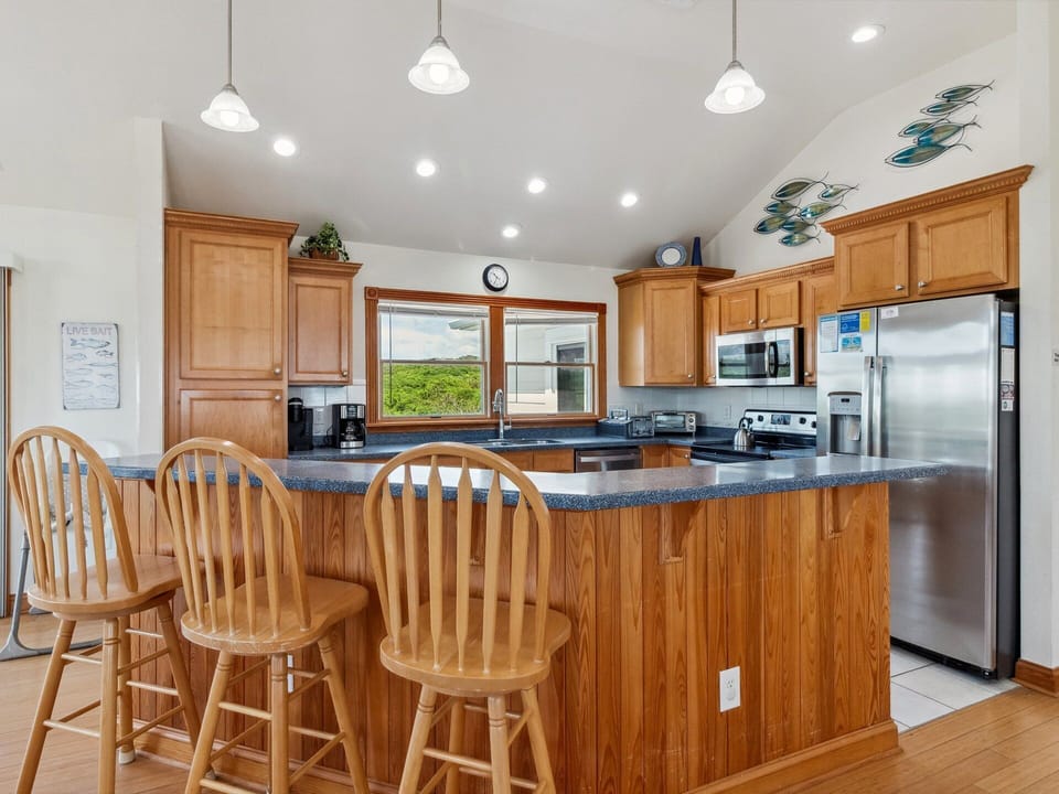 The Dining Area and Kitchen with a breakfast bar and built-in desk create a welcoming space for sharing meals and making memories.